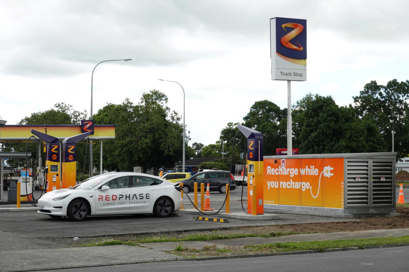 A photograph of an electric vehicle at a charging station.