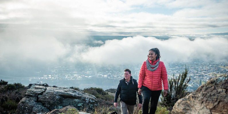 Two people walking up a hill