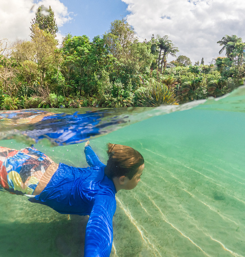 Boy swimming underwater in Lake Tarawera