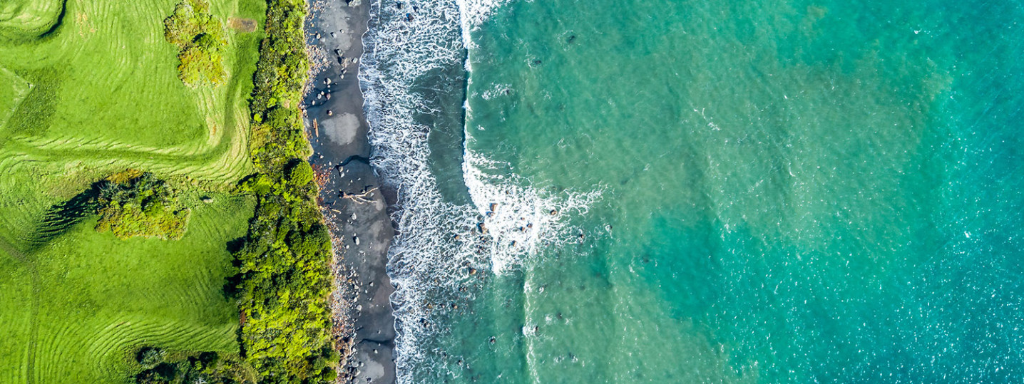 Overhead view of a beach shore and land.